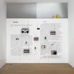 Art Review, 2013, 12 radios, cables, amplifier over photo mural Variable dimensions