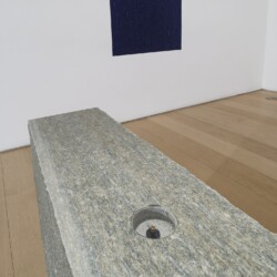 "Oltremare Verso Sud", 1967-2018, Yellow Lucerne granite, magnetic needle, glass, acrylic paint on wall Variable dimensions (Stone 70 x 80 x 16 cm Oltremare 70 x 80 cm)